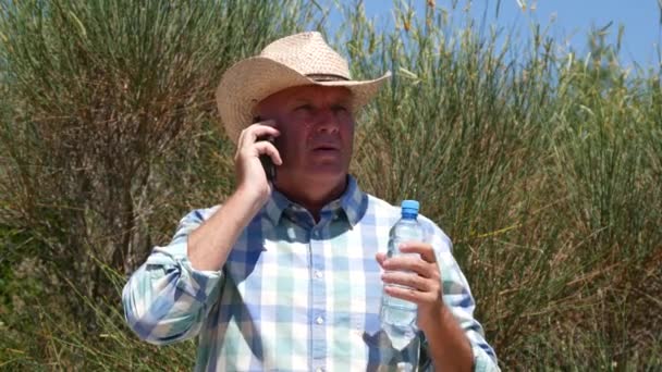 在炎热的一天 穿着牛仔帽在荒野中与手机交谈的人 — 图库视频影像