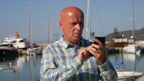 港湾使用携帯メールとチェック手時計時刻のビジネスマン — ストック動画