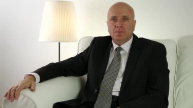 İşadamı kameraya bakıyor röportaj toplantıda bekle sakin koltukta oturan