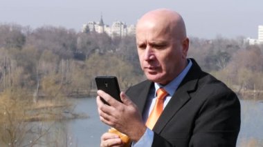 Mutlu işadamı almak kahvaltı lezzetli bir sandviç ve okuma hücre mesajları