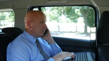 Cep telefonu ve dizüstü bilgisayar araba ile seyahat zamanında kullanarak iş işadamı konuş