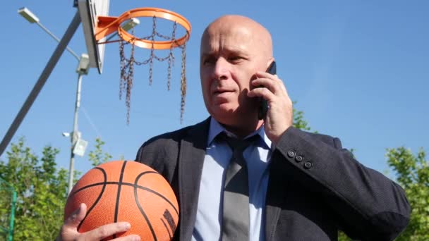 Бизнесмен Играющий Баскетбол Разговаривающий Мобильным Телефоном Игровой Паузе — стоковое видео