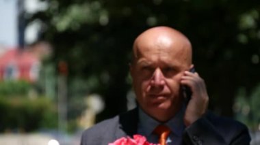 Cep telefonu için konuşan Çiçek ile bir aşk toplantı için giden adam ile görünümü Kapat
