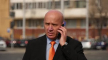 İş adamı sokakta yürümek ve konuşmak için cep telefon