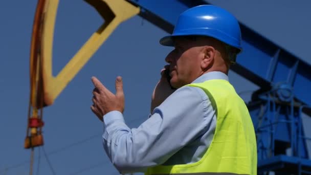 Engenheiro Companhia Petrolífera Conversando Com Telefone Celular Frente Uma Bomba — Vídeo de Stock