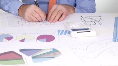 İş insanlar planlama çalışma diyagramları çizer ve hesap makinesi ile