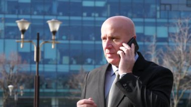 İş kişi el hareketi ve Şehir Merkezi görünümü açıklayan cep telefonu için konuşuyor