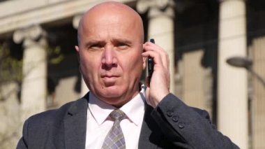 Cep telefonu için açıklayan ve mimik konuşurken işadamı ile sokak görünümü