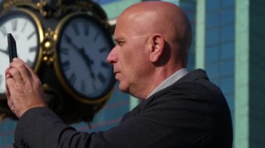 İş kişi sokakta şehir merkezinde cep telefonu kullanarak fotoğraf çekim