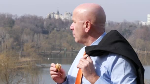 朝食のポーズで都市公園のおいしいおやつを食べて飢え実業家 — ストック動画