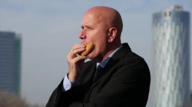 Lezzetli bir aperatif yemek şehir görünümü satıcı izlerken aç iş adamı.