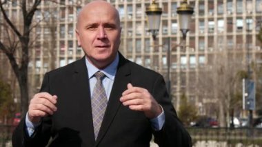 Bir sokakta konuşan işadamı Tv Reportage emlak piyasası hakkında röportaj