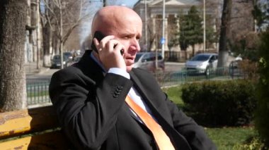 Kullanım hücre ve onay izle gülümseyen hareket eden Park Bench için konuşmandan işadamı.