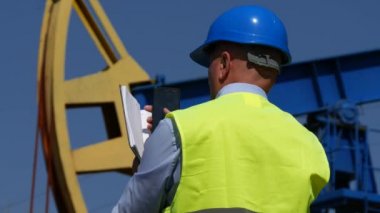 Teftiş yapan iş hareket eden ve gündem kullanarak pompa alanın açılan petrol mühendisi