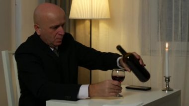 Bir bardak kırmızı şarap ile restoranda içki takım elbiseli işadamı