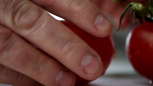 Cerrar imagen El hombre de la cocina corta un tomate rojo y jugoso — Vídeos de Stock