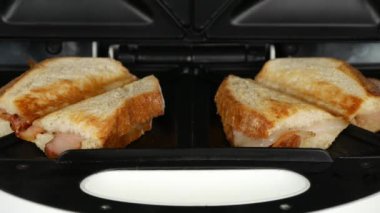 İki tane pastırmalı sandviç hazırlama tost makinesi açma adam elleriyle yakın çekim