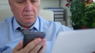 İşadamı cep telefonu kullanarak bir sözleşme ve erişim çevrimiçi bilgileri okuyun