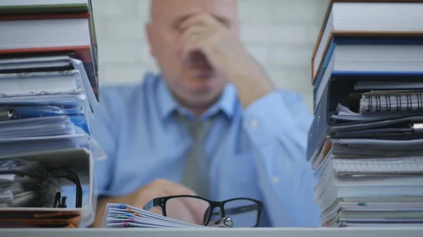 会計事務所で残業の手で彼の目をこすりながら疲れたビジネスマン — ストック写真