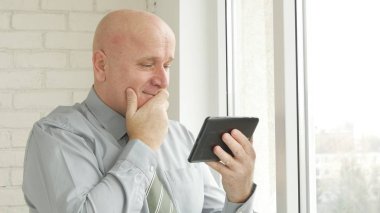 Tablet okuma iyi haber ve gülümseme kullanarak iş adamı