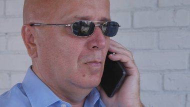 İşadamı siyah güneş gözlüğü ile telefon çağrısı yapma