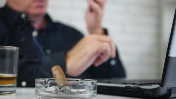 Blurred Image with Businessman Smoking a Cigar and Talking to Mobile — Stock Video