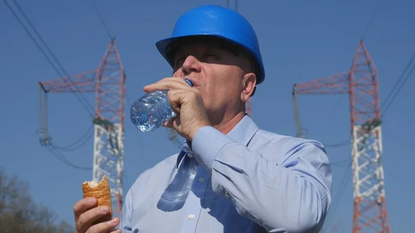 Ingeniero sediento bebe agua dulce y come un bocadillo — Foto de Stock