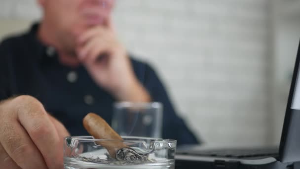 Un om de afaceri îngrijorat fumând un trabuc în biroul său — Videoclip de stoc