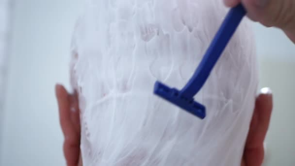 Nahaufnahme mit Mann, der sich im Badezimmer rasiert — Stockvideo