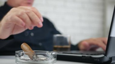 İşadamı dizüstü bilgisayarda Office Oda çalışmalarında bir puro duman
