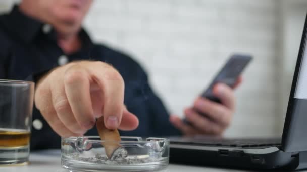 Бизнесмен, курящий сигарету и пьющий алкоголь Текст с помощью мобильного телефона — стоковое видео