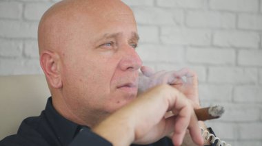 İş telefon sabit hat üzerinde konuşurken bir puro sigara işadamı görüntüsü