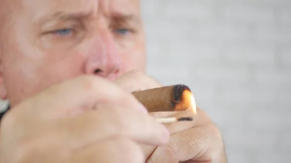 Image avec un homme d'affaires allumant un cigare aromatisé avec allumettes — Photo