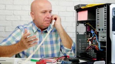 Telefon ve Gesticulate için bilgisayar bakım konuşmasında çalışan adam