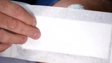 Yeni ve temiz bir bandaj ayak yaranın üzerine koyarak doktor