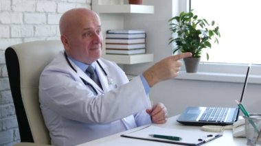 Doktor hastanede kabine için hasta gülümseme seyir ve parmak ile işaret