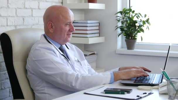 Médico feliz no armário do hospital usando a conexão sem fio do portátil — Vídeo de Stock
