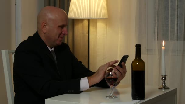 Επιχειρηματίας στο εστιατόριο κείμενο χρησιμοποιώντας το κινητό και γουλιά ένα ποτήρι με κρασί — Αρχείο Βίντεο