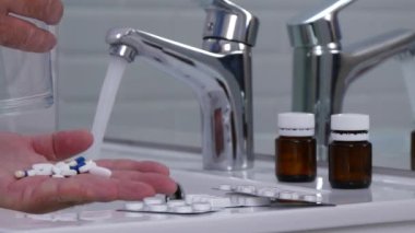 Adam çok fazla taze su ile hap almaya hazırlanıyor