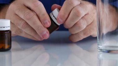 Adam bir ilaç alıcıyı açın ve tüm hapları masaya koy