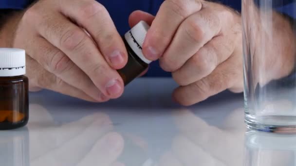 Un homme ouvre un récipiendaire de médicaments et met toutes les pilules sur la table 