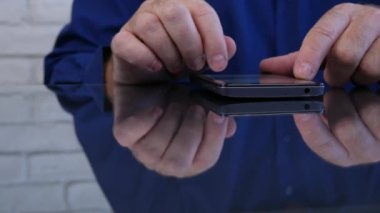 Bir Smartphone kullanarak Resepsiyon cam yüzey metin olarak yansıyan işadamı görüntüsü