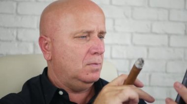 İşadamı duman aromalı puro ve Smartphone kullanarak metin