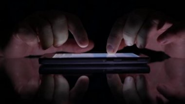 Bir karanlık yerde bir cep telefonu kullanan adam ellerini metin ile portre çekimleri
