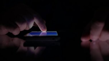 Bir karanlık yerde cep telefonu kullanarak tarama mali bilgilerini closeup adam eller