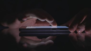 Karanlıkta mobil kablosuz uygulama kullanarak adam eller