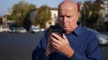 Sokakta yürürken cep telefonu kullanarak meşgul işadamı metin