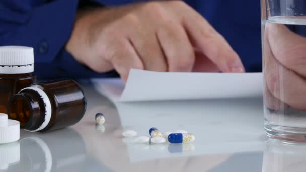 男子阅读和检查药物食谱在桌子上的药片 — 图库视频影像