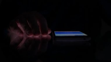 İşadamı bir cep telefonu yakınındaki masada parmaklarıyla sinirli hareketler yapmak