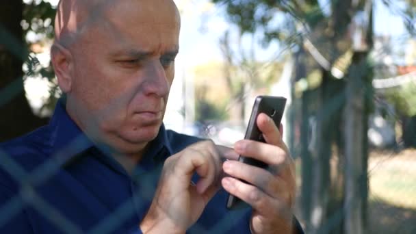 Mensaje Escritura Imágenes Hombre Serio Teléfono Celular Detrás Una Cerca — Vídeo de stock